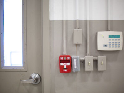 Door with fire alarm pull and security pad close by